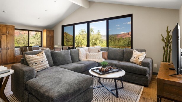 A modern living room with a sectional sofa, a coffee table, and a television. - The Sedona Sanctuary Hot Tub Unbeatable Views (Sedona)