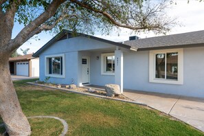 Ein modernes, zweistöckiges Haus mit Garage, Veranda und gepflegtem Rasen.
