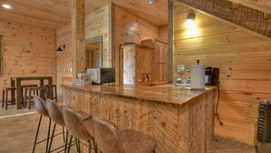 A wooden interior with a bar area, seating, and a kitchen. - Endless Views Hot Tub Movie Theater Firepit (Mineral Bluff)