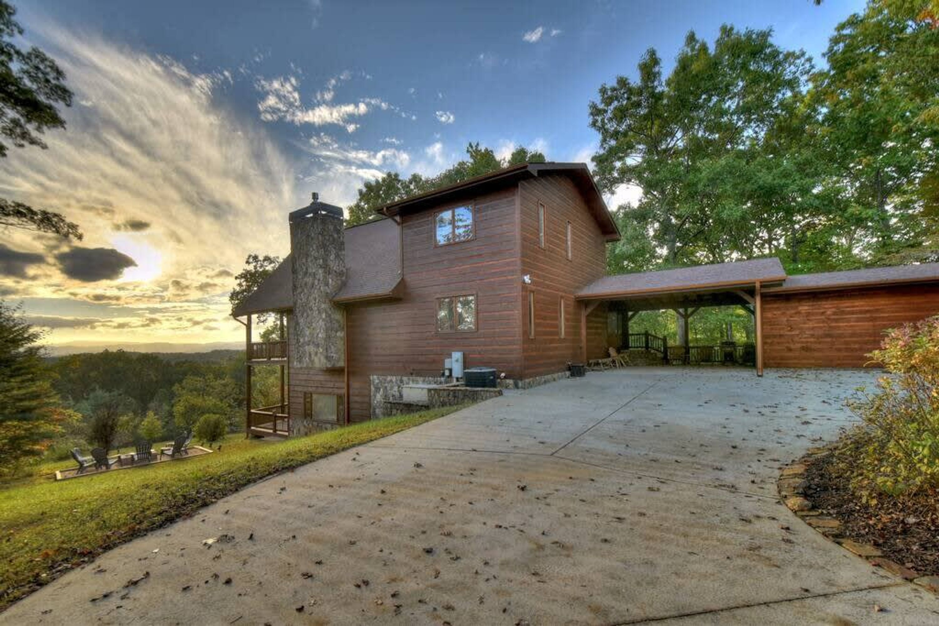 A two-story wooden house with a garage, a covered porch, and a concrete driveway.