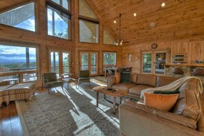 Una cabaña de madera espaciosa con amplias ventanas, un rincón de estar acogedor y una chimenea de piedra.
