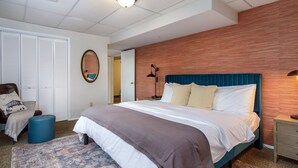 Una camera d'albergo con un letto, un comodino, una lampada e un armadio.