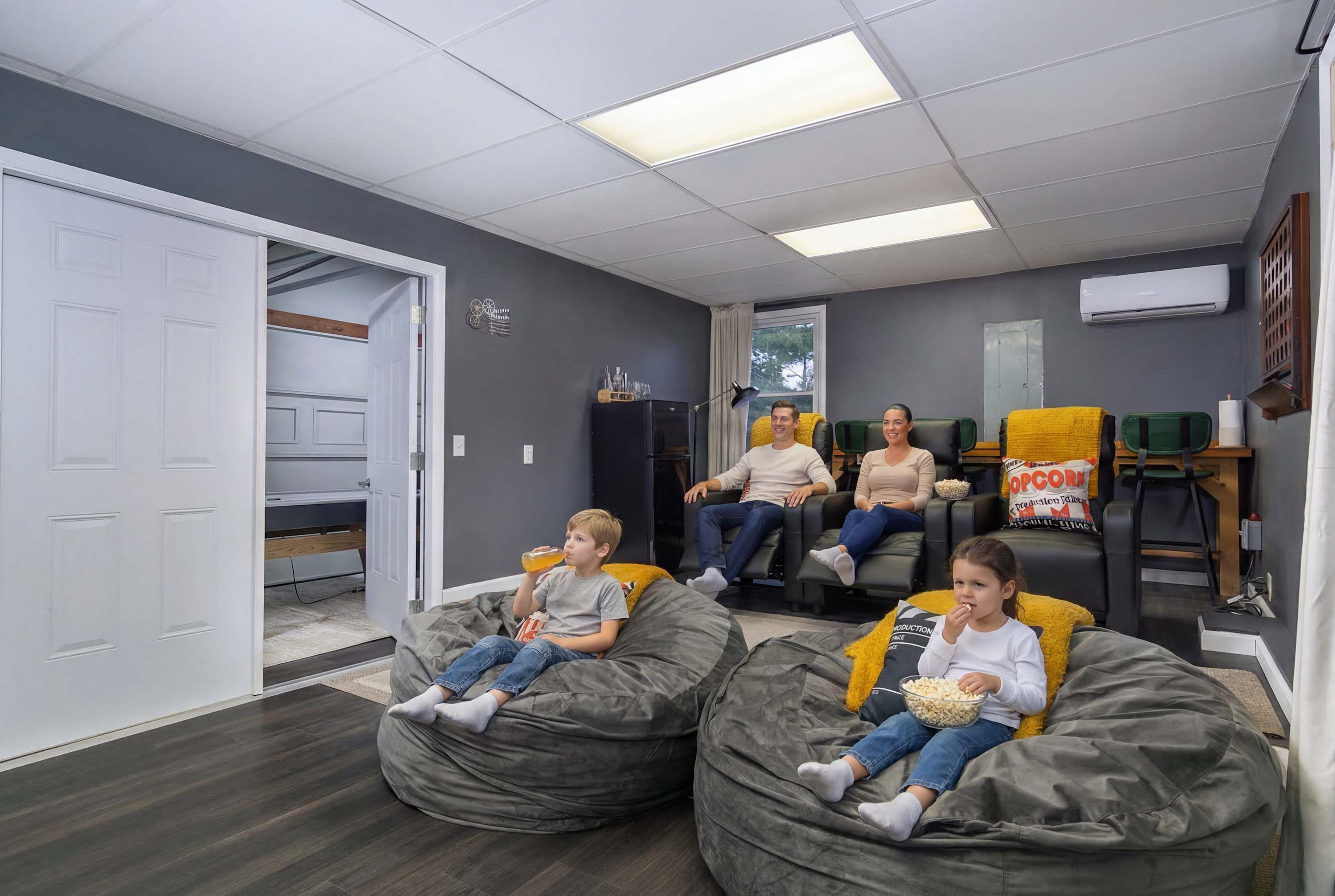 A room with bean bags, a couch, and a table with popcorn.