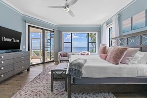 A bedroom with a bed, a TV, a ceiling fan, and a view of the ocean. - Luxury Beachfront Retreat Pool Game Room Sleeps 16 (Bradenton)