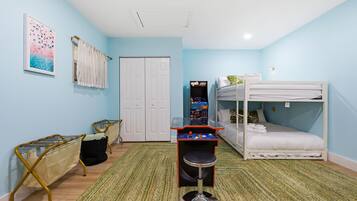 Una habitación con literas, un escritorio con computadora, una silla y una puerta.