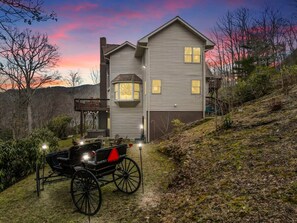 Une maison à deux étages avec un porche abrité et une remise.