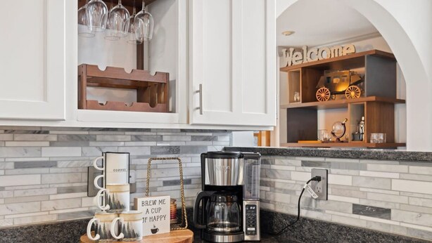 A kitchen with a coffee maker, a tray with coffee mugs, and a sign that says 'Brew me a cup if happy.' - 6 Br Sleeps 16 - Game Room - Hot Tub - Firepit (Fairview)