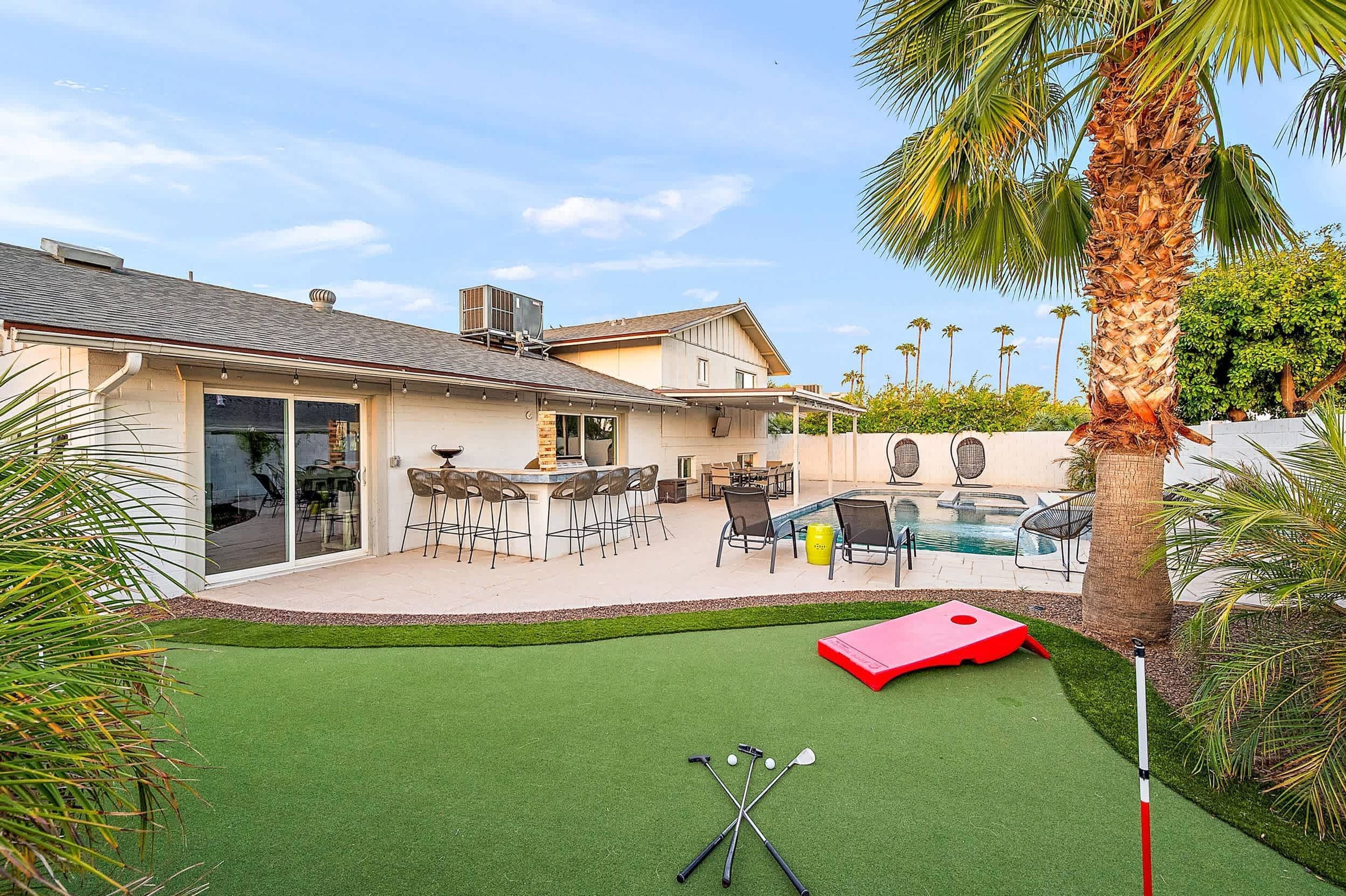 Une propriété résidentielle dotée d’une piscine, d’un espace de détente avec mobilier de jardin et d’une pelouse.