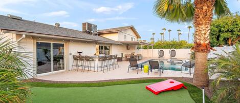 Une propriété résidentielle dotée d’une piscine, d’un espace de détente avec mobilier de jardin et d’une pelouse.