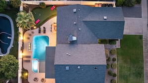 En boligejendom med swimmingpool, terrasse og en stor overdækket træterrasse.