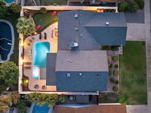 Ein Wohnhaus mit Swimmingpool, Terrasse und einer großen überdachten Veranda.