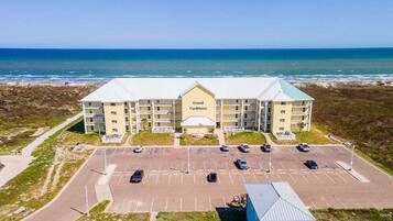 A Grand Caribbean hotel with a parking lot and ocean view.