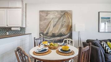 En matplats med ett runt bord, stolar och en målning som föreställer en segelbåt.