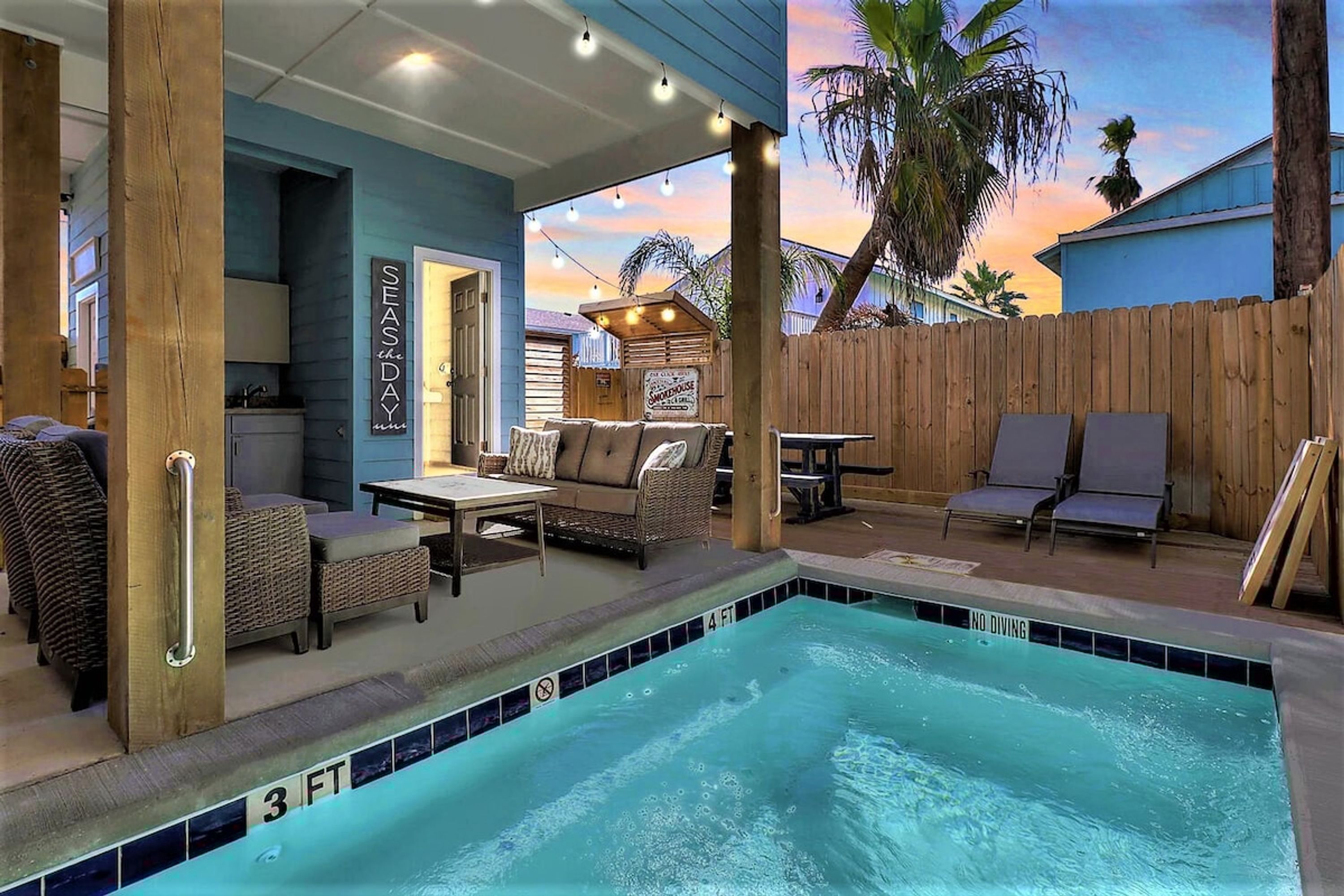 A pool area with a 4 FT depth marker, lounge chairs, and a sign for 'SEASDAY'.
