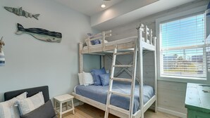 A bunk bed room with a small table and a couch. - One Click Away Private Pool EV Charger Beach Toys (Port Aransas)