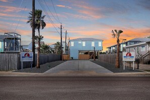 A residential street with houses, a wooden fence, and a clear sky. - One Click Away Private Pool EV Charger Beach Toys (Port Aransas)