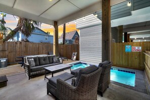 An outdoor patio with a pool, lounge chairs, and a wooden fence. - One Click Away Private Pool EV Charger Beach Toys (Port Aransas)