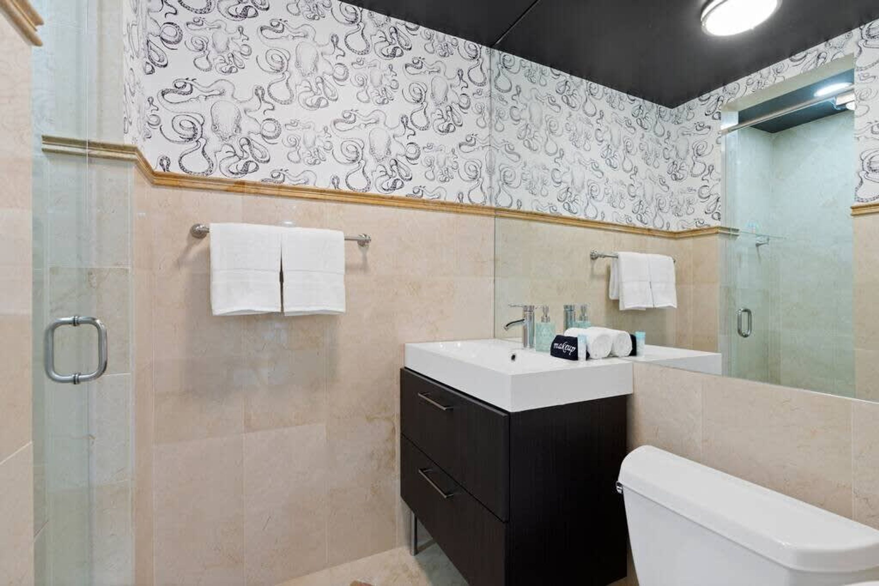 Un bagno con doccia, toilette, lavandino e specchio.