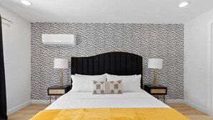 A bedroom with a black headboard, white bedding, two bedside lamps, and a patterned wallpaper. - Heated Pool - Luxury Kitchen - 1 Mile to Beach (Fort Lauderdale)