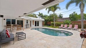 A modern house with a swimming pool, outdoor furniture, and a patio area. - Heated Pool - Luxury Kitchen - 1 Mile to Beach (Fort Lauderdale)