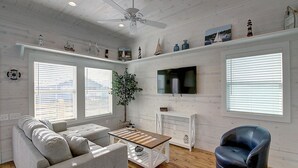 Una sala de estar con sofá, mesa de centro, televisor y chimenea.