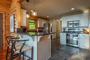 A modern kitchen with a central island, stainless steel appliances, and a view of the outdoors. - Sunset Views for Miles Gameroom Hottub - Fire Pit (Mars Hill)