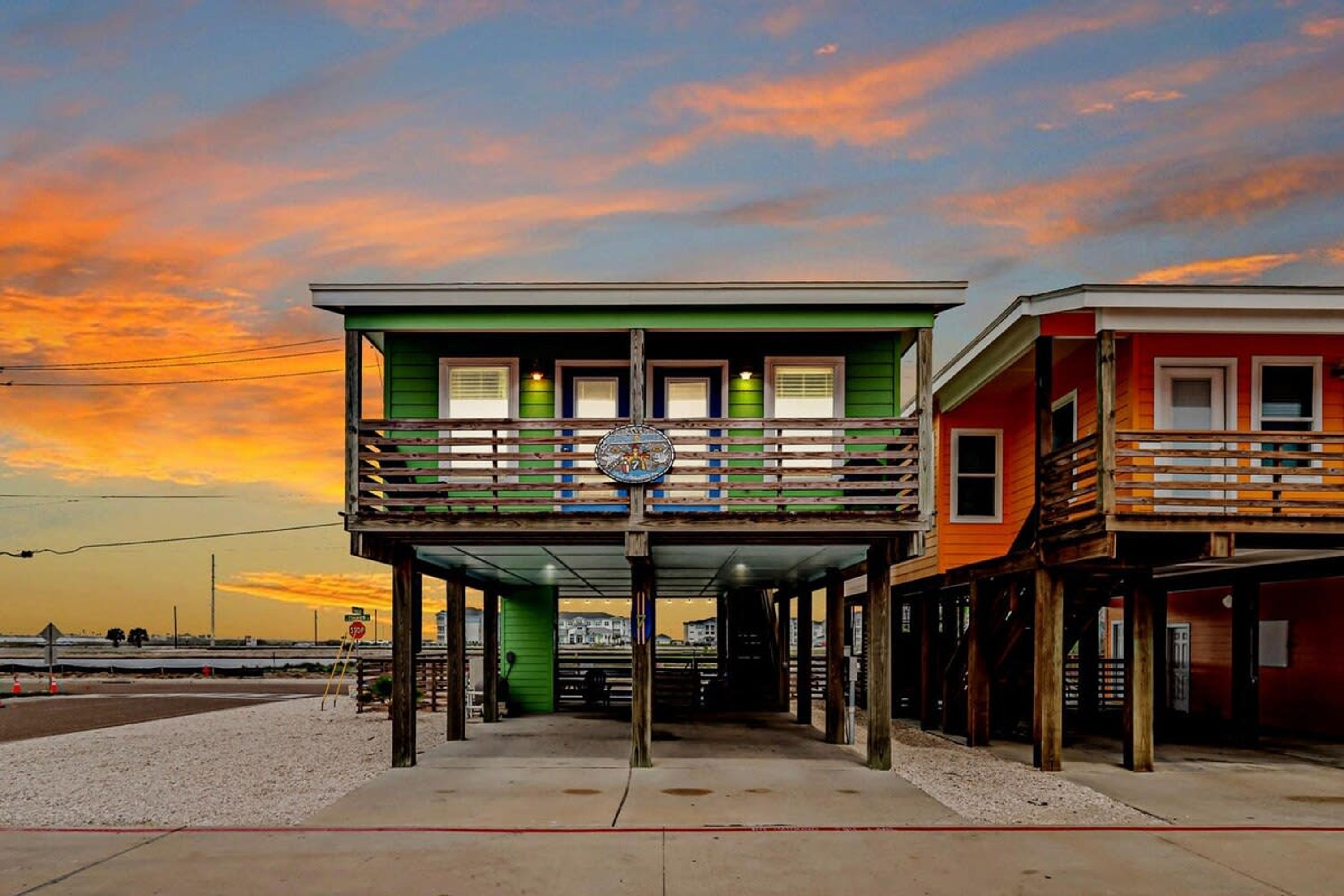 A two-story building with a balcony, a sign, and a view of the beach.