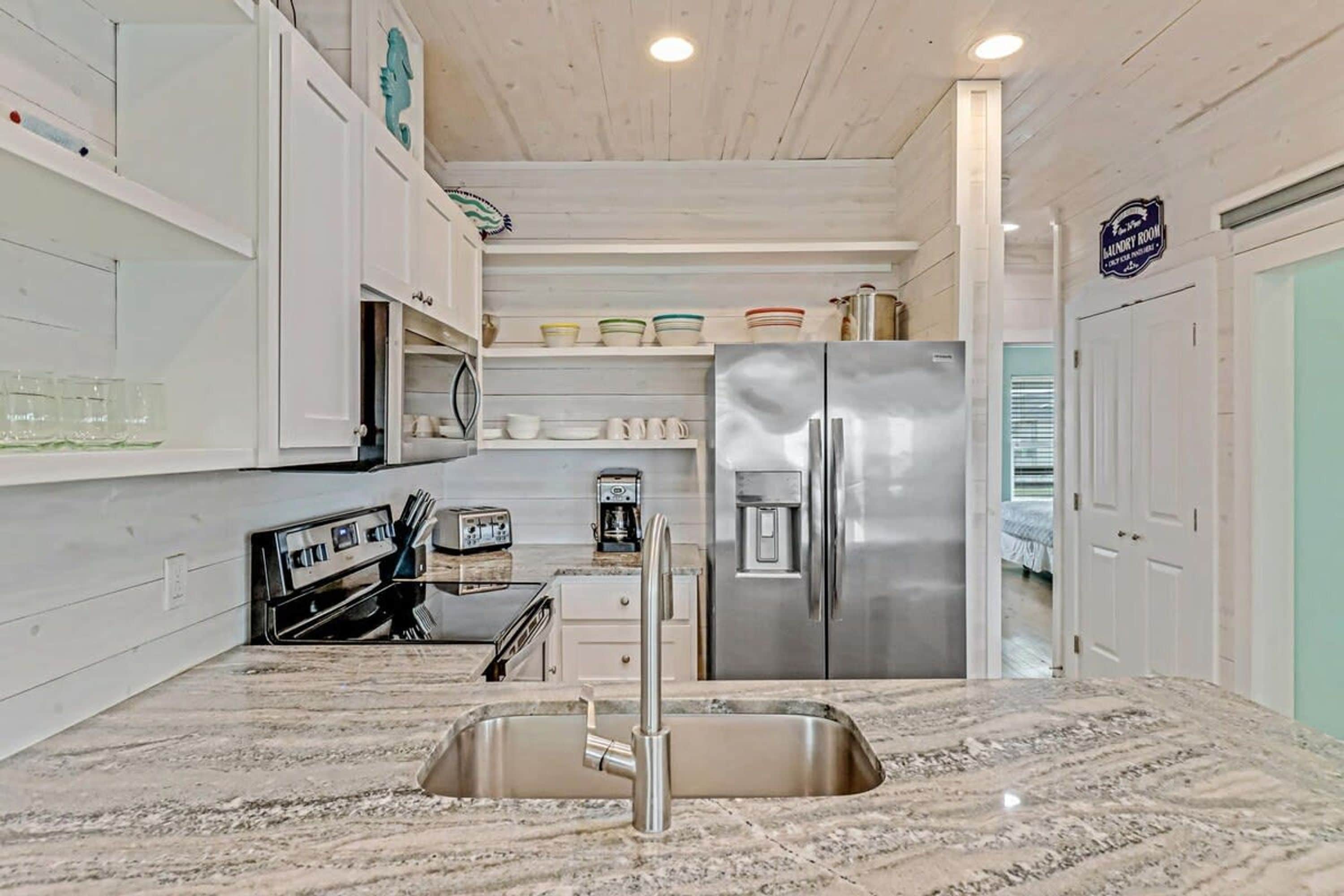 A modern kitchen with a stainless steel refrigerator, a built-in oven, and a sink.