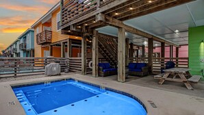 A pool area with a hot tub, wooden deck, and outdoor seating. - Stairway to Seven- Private Pool Hammocks (Port Aransas)