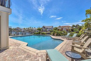 A swimming pool with lounge chairs and a view of residential buildings. - Waterfront Home Pool Golf Cart Dock Sleeps 16 (Destin)