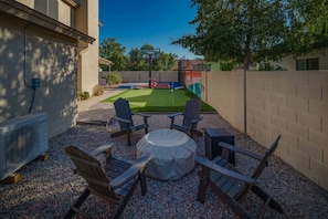 An outdoor patio with a table and chairs, a covered seating area, and a basketball hoop. - Peoria Paradise Basketball Heated Pool Games (Peoria)