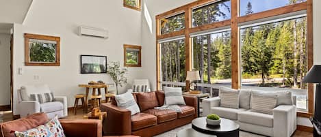 A spacious living room with large windows, a fireplace, and a cozy seating area.