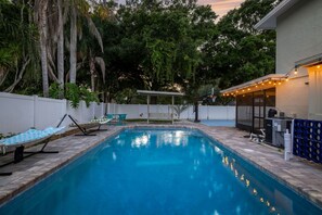 A swimming pool with a white fence, a hammock, and a covered seating area. - Hot Tub Sportscourt Game Room 5 min to Beach (Seminole)
