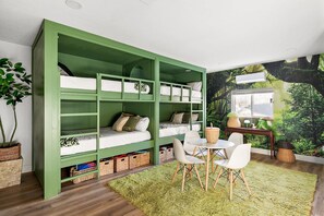 A room with a green bunk bed, a small table with chairs, a green rug, and a wall mural. - The Desert Emerald Pool Hot Tub Games More (Scottsdale)