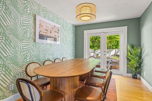 Ein Konferenzraum mit Holztisch und -stühlen, einem gerahmten Bild an der Wand und Blick durch die Glastür.