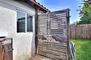 Um portão de madeira com uma tranca de metal, uma janela e um deck de madeira.
