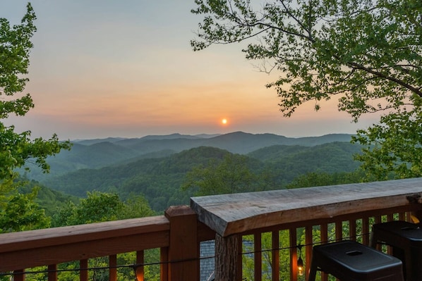 A wooden deck overlooking a mountainous landscape with a sunset. - The Triple Timber in Mars Hill (Mars Hill)