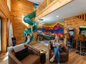 A wooden interior with a green slide, pool table, and gaming machines. - The Triple Timber in Mars Hill (Mars Hill)