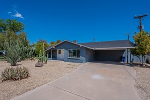 A single-story house with a garage, a driveway, and a variety of desert vegetation. - 4 Br Tempe Retreat Pool Putt Putt Pool Table (Tempe)