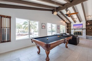 A spacious room with a pool table, a fireplace, and large windows. - 4 Br Tempe Retreat Pool Putt Putt Pool Table (Tempe)