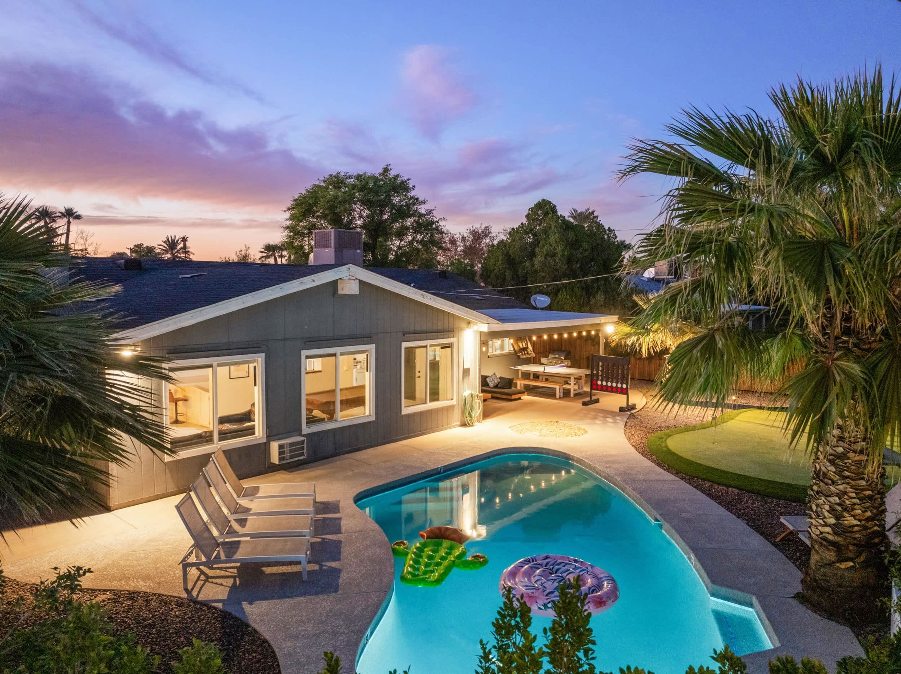 Uma casa com piscina, área de estar ao ar livre e um pátio.