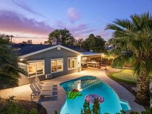 Uma casa com piscina, área de estar ao ar livre e um pátio.