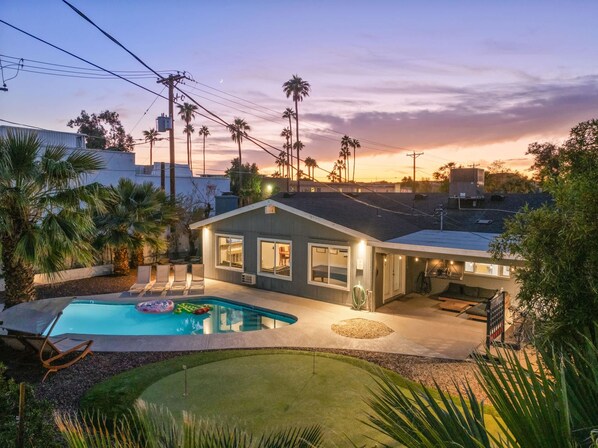 A residential property with a swimming pool, a covered patio, and a view of the sunset. - 4 Br Tempe Retreat Pool Putt Putt Pool Table (Tempe)