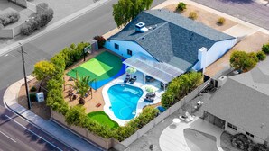 A residential property with a swimming pool, a tennis court, and a covered patio area. - Epic Desert Stay Pool Hot Tub Sports Court (Scottsdale)