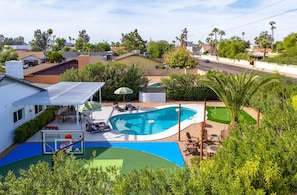 A residential area with a swimming pool, patio furniture, and a basketball court. - Epic Desert Stay Pool Hot Tub Sports Court (Scottsdale)