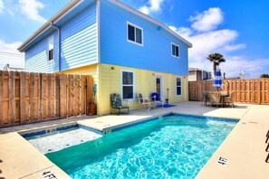 A two-story house with a swimming pool, wooden fence, and outdoor furniture. - Nauti Mermaid Private Pool Sleeps 14 Dog Friendly (Port Aransas)