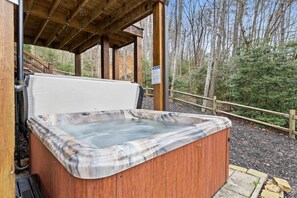 A hot tub with a wooden exterior, located outdoors with a wooden deck and a wooden fence in the background. - Blue Ridge Cabin Stunning Views Hot Tub Game Room (Cherry Log)