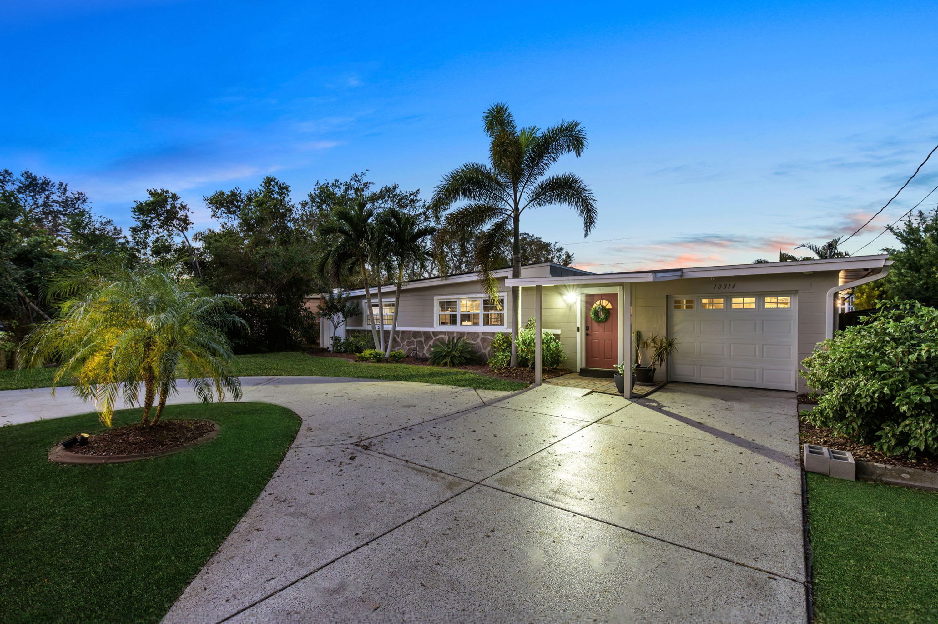 A residential house with a driveway, a front porch, and a garage.