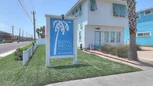 A sign for Royal Palms Cottages with a palm tree logo, located at 2606 South Eleventh. - Casa Bella- Community Pool View 0 3 mi to Beach (Port Aransas)