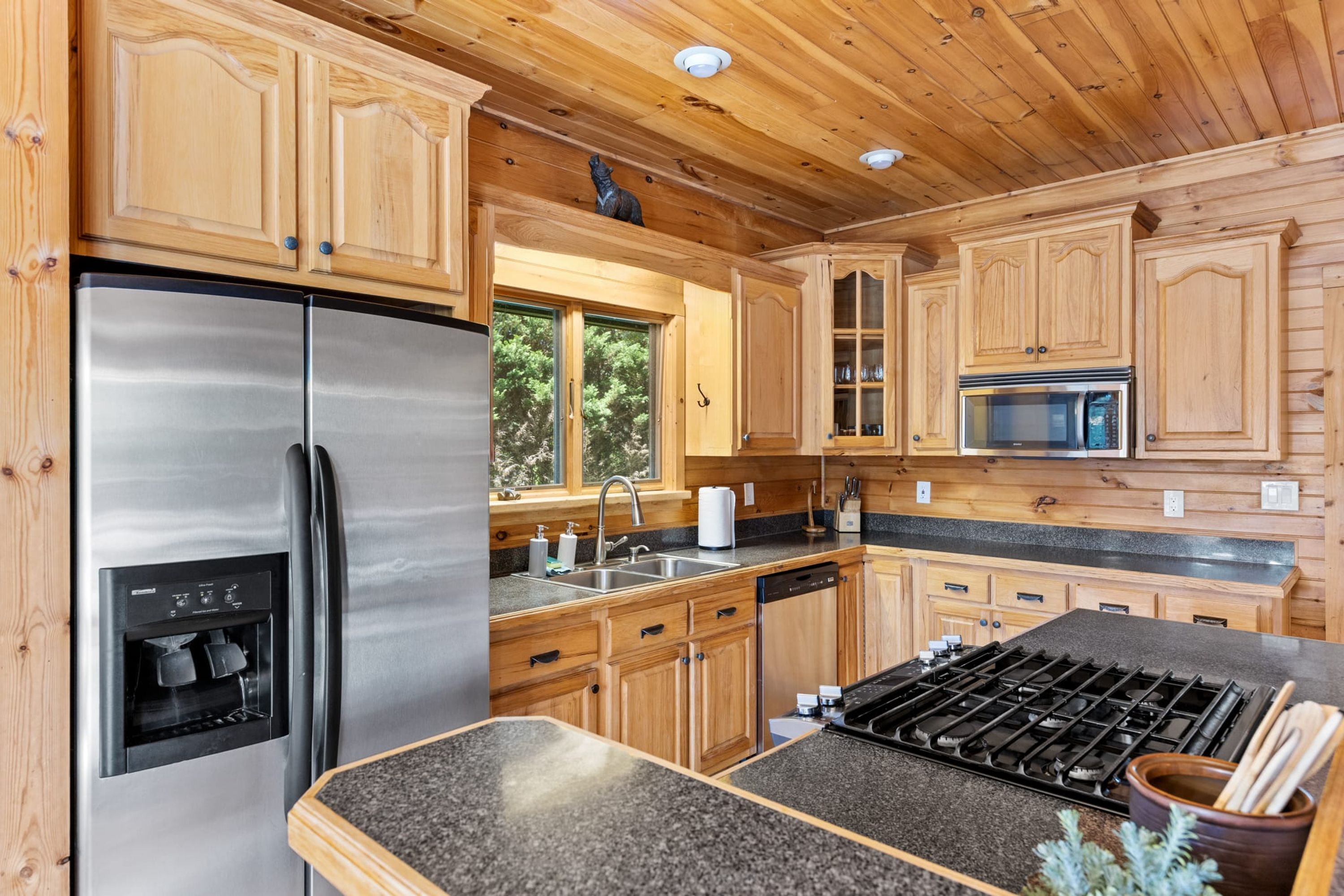 Une cuisine moderne avec des meubles en bois, des appareils en acier inoxydable et un plan de travail en granit.